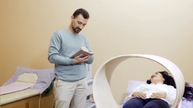 Doctor-jokes-with-patient-during-magnetotherapy-in-clinic