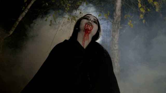 Maléfique-weibliche-Zombie-Vampir-raus-aus-einem-nebligen-Wald-nachts-im-Mondlicht-um-Halloween-zu-feiern