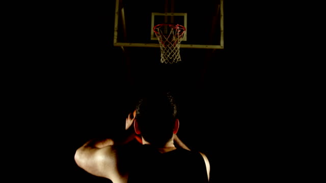Jugador-de-baloncesto-masculino-lanzamiento-de-baloncesto-en-el-aro-de-baloncesto-de-4k