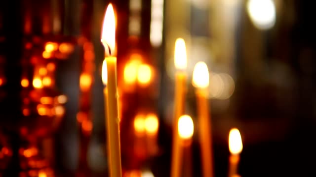 Eine-brennende-Kerze-im-Fokus,-die-orthodoxe-Kirche