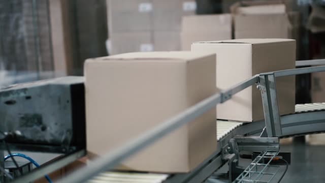 Cajas-de-cartón-en-banda-transportadora-en-fábrica.-Clip.-Línea-de-producción-en-que-se-mueven-las-cajas