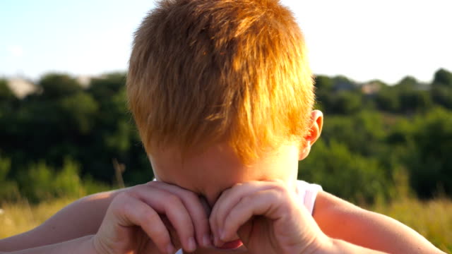 Portrait-of-sad-children-with-emotions-and-feelings.-Young-red-hair-boy-with-freckles-looking-at-camera-and-crying-outdoor.-Little-kid-closing-eyes-with-his-hands.-Close-up-Slow-motion