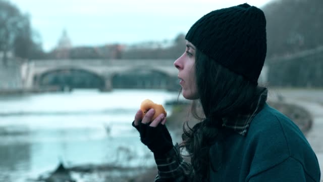 lonely-homeless-young-woman-eating-an-apple