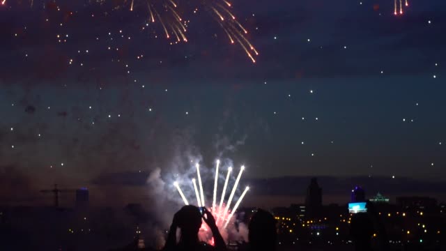 Eine-Gruppe-von-Menschen-beobachten-Feuerwerk-in-der-Nacht-durch-den-Fluss.-Slow-Motion.-HD