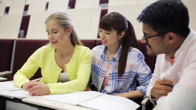 group-of-students-with-notebooks-in-lecture-hall