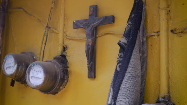 Jesus-auf-ein-Kruzifix-hängen-an-der-Wand-neben-dem-Stromzähler-und-einen-Pullover