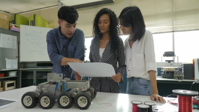 Team-von-Elektronik-Ingenieur-zusammen-arbeiten,-gemeinsam-an-einem-Projekt-arbeiten,-Roboter-zu-bauen.-Menschen-mit-Technologie-oder-Innovation-Konzept.