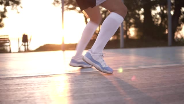 Close-up-of-female-basketball-player-legs-in-white-golf-socks-doing-dribbling-exersice-very-quickly,-run-backwards,-training-outdoors-on-the-local-court