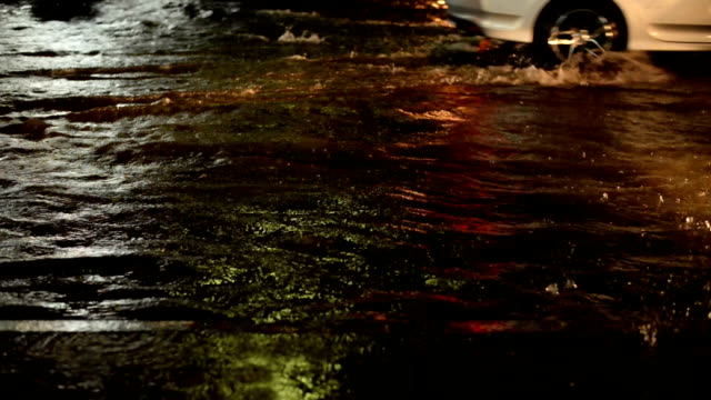 Flood-road-traffic-on-a-rainy-night-with-splash-from-cars