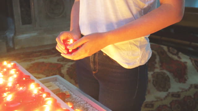 Woman-holding-candle-near-altar-in-church.