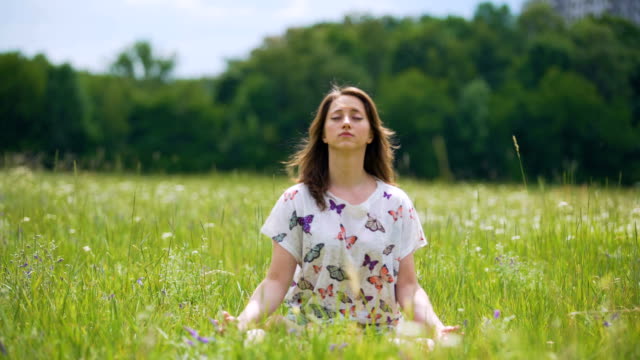 Oneness-with-nature,-young-female-brunette-closed-eyes-and-meditates-outdoors