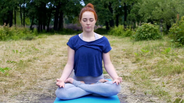 Sinnende-Frau-in-Lotus-Pose-im-Freien,-weibliche-öffnet-die-Augen-nach-tiefer-meditation