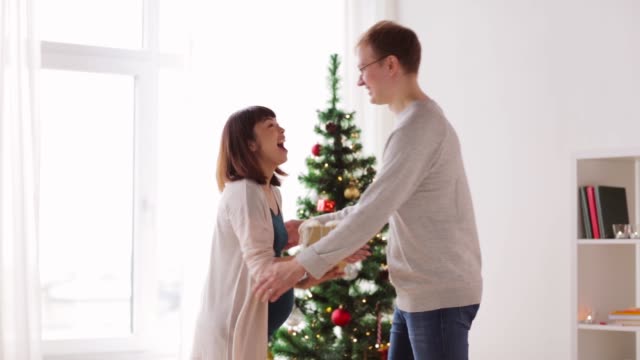 Ehemann-geben-Weihnachtsgeschenk-für-schwangere-Frau