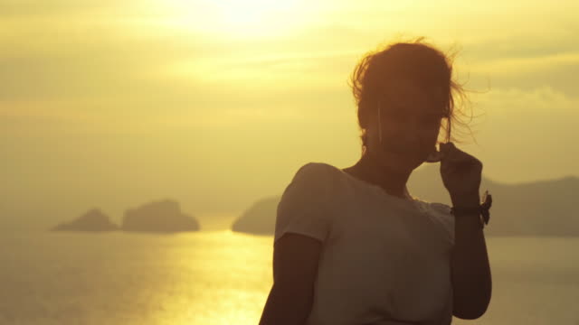 Schöne-junge-Frau-bunte-Kleid-Mode-mit-Rock-und-Hut-posiert-für-die-Kamera-bei-Sonnenuntergang-auf-der-italienischen-Insel-Ponza-Berg-Küste.