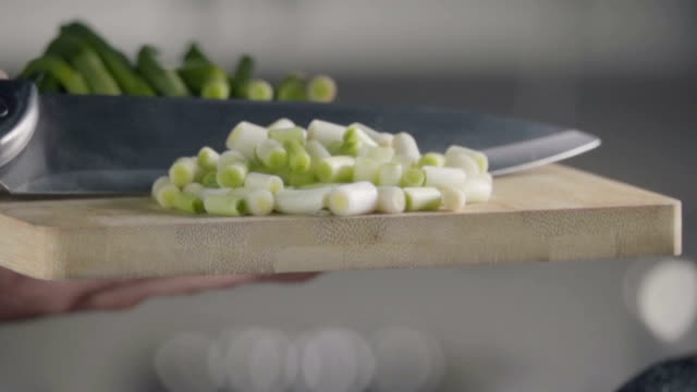 Falling-of-green-onion-into-the-frying-pan.-Slow-motion-480-fps