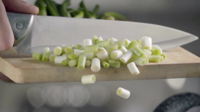 Falling-of-green-onion-into-the-frying-pan.-Slow-motion-480-fps