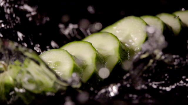 Falling-of-sliced-cucumber-into-the-wet-table.-Slow-motion-480-fps