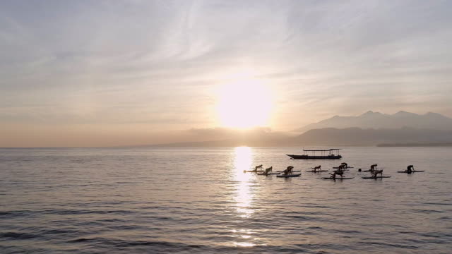 Sunrise-Yoga-Kurs-auf-Stand-Up-Paddle-Boards-in-den-Ozean-der-Ruhe