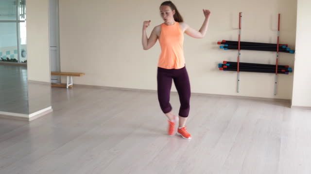 Young-pretty-girl-doing-dance-exercises-in-gym-or-studio.-fitness,-sport,-dance-and-lifestyle-concept