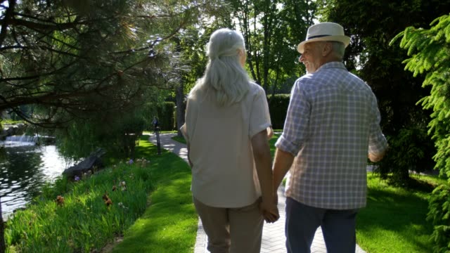 Älteres-Paar-beim-Spaziergang-im-Park-umarmt