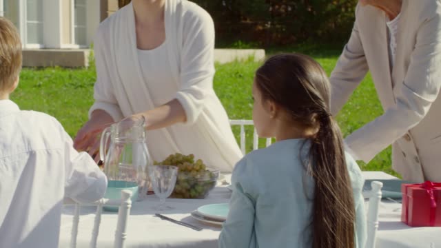 Mehrgenerationenübergreifende-Familien-Setting-Tisch-zum-Geburtstag-Dinner-im-Freien