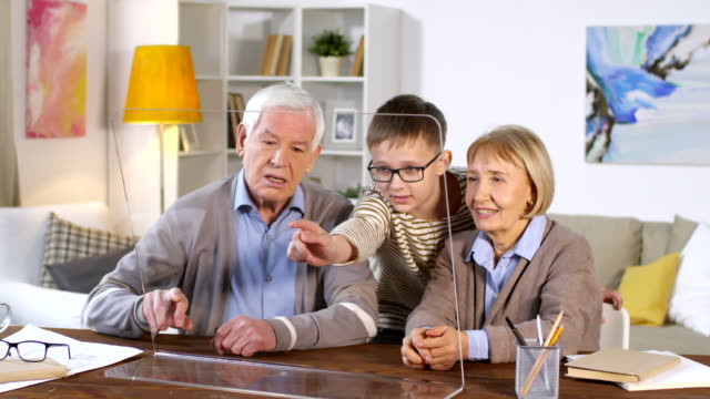 Abuelos-y-nietos-usando-pantalla-AR-transparente