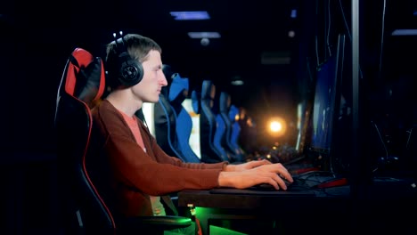 Friends playing video game at home. Gamers playing online in dark room lit  by neon lights. Competition and having fun - a Royalty Free Stock Photo  from Photocase