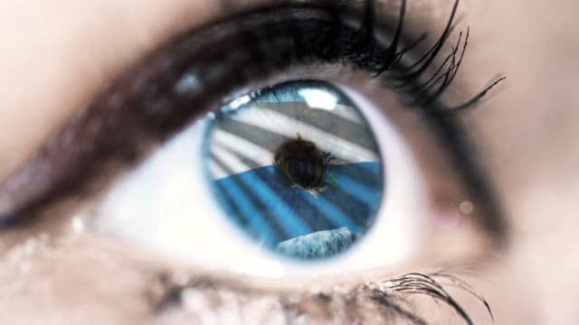 mujer-ojo-azul-en-primer-plano-con-la-bandera-de-San-Marino-en-el-iris-con-el-movimiento-del-viento.-concepto-de-vídeo