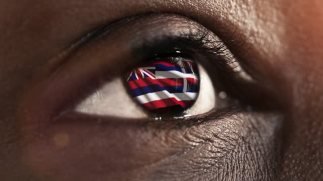 Mujer-ojo-negro-en-primer-plano-con-la-bandera-del-estado-de-Hawái-en-iris,-estados-unidos-de-América-con-movimiento-de-viento.-concepto-de-vídeo