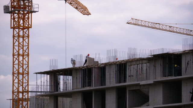 Constructores-en-el-borde-de-un-rascacielos-en-construcción.-Trabajadores-en-una-obra-de-construcción