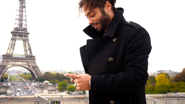 Ausländischen-Freund-im-Chat-mit-französischen-Mädchen-auf-Smartphone-rund-um-Eiffelturm-in-Zeitlupe