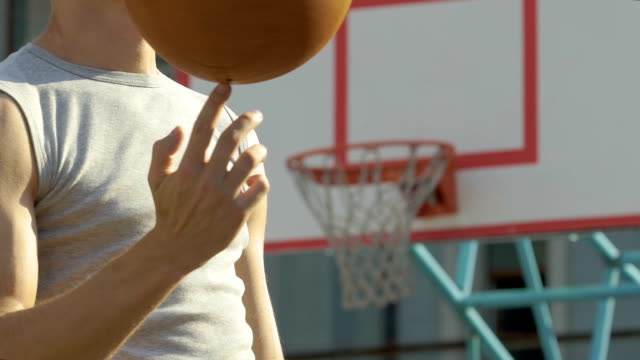 Musculoso-atleta-caucásico-magistralmente-spinning-baloncesto-en-su-dedo,-truco