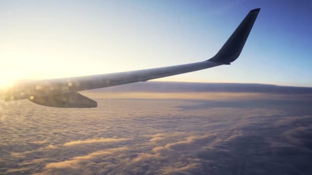 Sonnenuntergang-am-Himmel-aus-dem-Flugzeug-Fensterflügel-des-Flugzeugs.