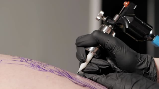 Tattoo-artist-make-tattoo-at-the-studio,close-up