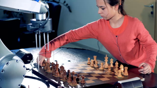 Kleines-Mädchen-Verlauf-Schachbrett-für-spielt-Schach-mit-einem-Roboter.
