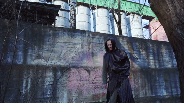 Grim-reaper-or-angel-of-death-on-INDUSTRIAL-URBANISTIC-LANDSCAPE-Goes-to-the-camera-and-closes-the-lens-by-hand.