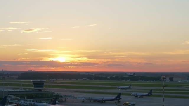 Vista-del-aeropuerto-en-puesta-de-sol,-avión-despegando