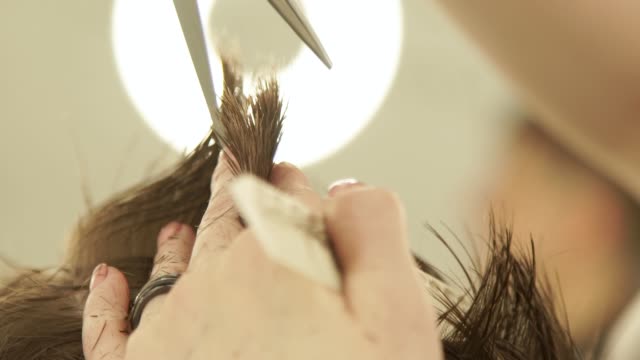 Haircutter-hands-making-haircut-with-scissors-and-comb.-Hairdresser-cutting-hair-with-hairdressing-scissors-in-barber-shop.-Close-up-barber-haircut-with-comb-in-beauty-salon