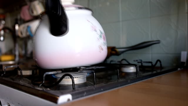 ignites-the-gas-on-the-stove-to-put-the-kettle