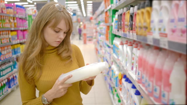 Junge-Frauen-die-Wahl-Haushaltschemikalien-im-Supermarkt.