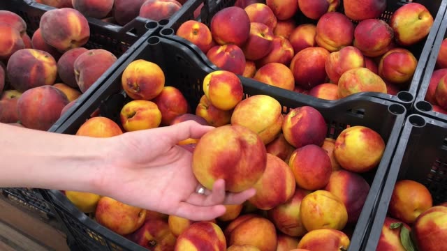 Woman-picking-peaches-in-the-supermarket