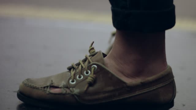 Slow-motion-of-person's-broken-shoe-as-he-waits-at-a-subway-station