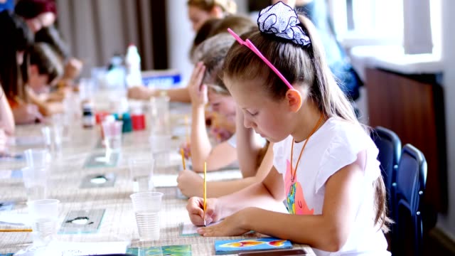 Zeichnung-Lektion,-im-Klassenzimmer,-ziehen-Kinder-mit-Farben,-Meister-die-Technik-des-Zeichnens-auf-Glas.-im-Vordergrund-zeichnet-ein-schönes-acht-jährige-blonde-Mädchen-mit-Leidenschaft