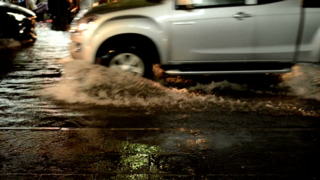 Camino-de-la-inundación-en-lluvia-de-la-noche-caen-con-motos-y-coches-como-fondo