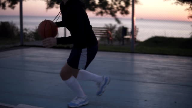 Young-female-basketball-player-plying-in-the-morning-on-the-local-court.-Young-girl-running-with-a-ball-and-throw-it-into-the-net