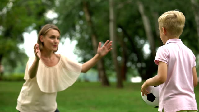 Niño-jugando-al-fútbol-con-mamá-en-el-parque,-Feliz-fin-de-semana-familiar,-estilo-de-vida-saludable
