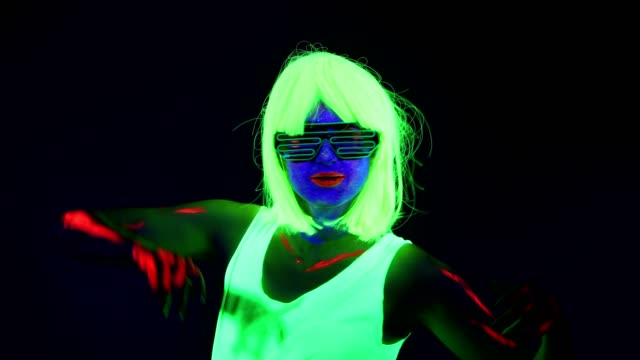 Woman-with-UV-face-paint,-wig,-glowing-glasses,-clothing-portrait-shaking-her-head.-Caucasian-woman.-.