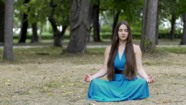 Señora-hermosa-meditación-al-aire-libre,-morena-de-pelo-largo-mujer-en-parque,-postura-de-loto