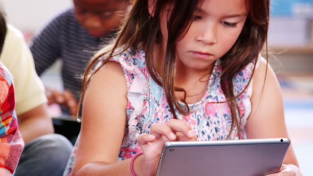 Zwei-Grundschüler-mit-tablet-Computern-in-der-Klasse