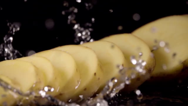 Falling-of-sliced-potatoes-into-the-wet-table.-Slow-motion-480-fps